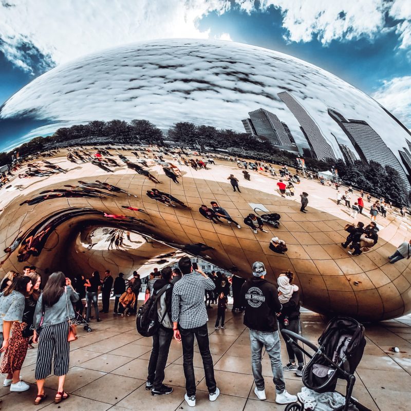 a group of people that are standing near the Cloud Gate in Chicago